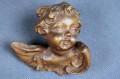 Uskrzydlona mała główka putta wyrzeźbiona