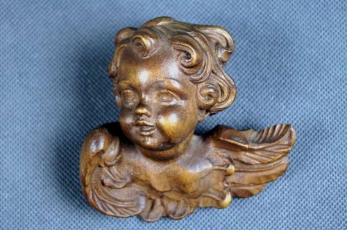 Mała uskrzydlona główka putta wyrzeźbiona