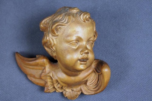 Wyrzeźbiona głowa amora w drewnie