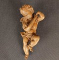 Jasna, drewniana rzeźba przedstawia pulchnego cherubinka grającego na mandolinie. Aniołek jest w ruchu, z uniesioną nogą i przechyloną głową. Widać małe skrzydła i krótkie, kręcone włosy. Całość emanuje radością i muzykalnością.