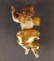 Polichromowana rzeźba z drewna przedstawia amorka ze skrzydełkami, unoszącego się w dynamicznej pozie i grającego na skrzypcach. Jego ciało ma jasną, cielistą barwę. Twarz amorka jest skierowana w stronę widza
