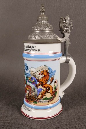 Okolicznościowy kufel piekarniczy z 1910 roku wykonany z białej porcelany i posiada cynowe wieczko z ozdobnym uchwytem przedstawiającym lwa. Kufel ozdobiony jest kolorowymi, litografiami podmalowywanymi przedstawieniami scen związanych z cechem piekarzy.