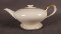 Wykonany z najwyższej jakości porcelany, imbryk do herbaty z podstawką z serwisu. Wykonany w renomowanej niemieckiej wytwórni porcelany, w pięknym odcieniu koloru ecru. Udekorowany imponującymi złoceniami.