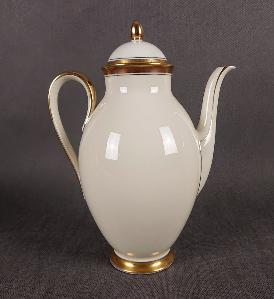 Dzbanek do kawy Księżna. Porcelanowy serwisowy dzbanek do kawy. Atutem tego herbacianego dzbanka jest wykonanie z najwyższej jakości porcelana w pięknym odcieniu koloru ecru i finezyjnych kształtach. Udekorowany efektownymi złoceniami.