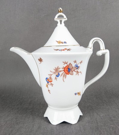 Dzbanek do kawy Sorau, wykonany z białej porcelany, charakteryzuje się klasyczną, elegancką formą, typową dla okresu międzywojennego i stylu Art deco. Ma stożkowaty kształt, rozszerzający się ku podstawie, która jest stabilna i lekko rozkloszowana.