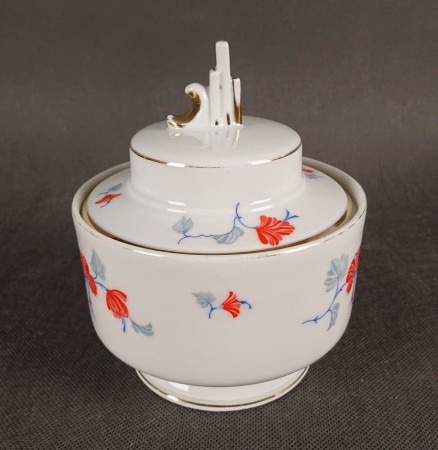 Przedwojenna porcelanowa bomboniera w stylu Art Deco, wyprodukowana w Niemczech przez manufakturę Beyer & Bock w Volkstedt, prezentuje charakterystyczne dla tej epoki połączenie geometrycznych form z delikatnymi zdobieniami.