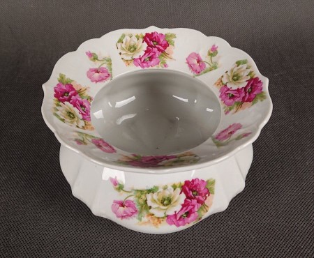 Przedwojenna porcelanowa spluwaczka, zwana również kraszuarką, wyprodukowana w Niemczech. Wykonana z białej, szkliwionej porcelany i składa się z dwóch głównych, połączonych ze sobą części: dolnej, pękatej, oraz górnej, o szeroko rozchylonym kołnierzu.