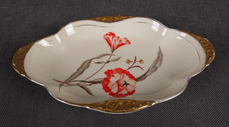 Kunsztowna patera Thomas wykonany z najwyższej jakości porcelany w kolorze ecru. Dekorowany motywami kwiatowymi w kolorze czerwieni i zieleni oraz złoceniami. Patera idealny do kolekcji.