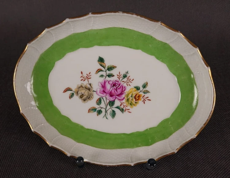 Porcelanowa patera z KPM Berlin, wykonana z białej szkliwionej porcelany, ma owalny kształt z falowanymi brzegami, nawiązującymi do stylu rokoko lub klasycystycznego. Krawędź patery jest podkreślona złoceniem, co dodaje jej elegancji.