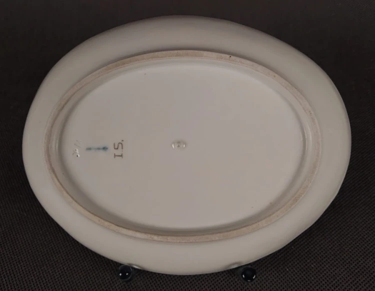 Porcelanowa patera z KPM Berlin, wykonana z białej szkliwionej porcelany, ma owalny kształt z falowanymi brzegami, nawiązującymi do stylu rokoko lub klasycystycznego. Krawędź patery jest podkreślona złoceniem, co dodaje jej elegancji.