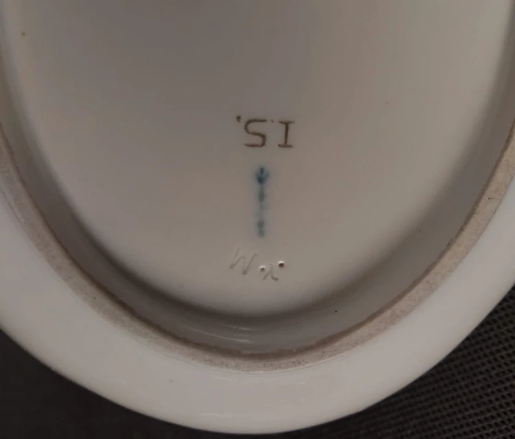 Porcelanowa patera z KPM Berlin, wykonana z białej szkliwionej porcelany, ma owalny kształt z falowanymi brzegami, nawiązującymi do stylu rokoko lub klasycystycznego. Krawędź patery jest podkreślona złoceniem, co dodaje jej elegancji.