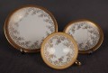 Porcelanowy zestaw śniadaniowy z niemieckiej fabryki Hertel Jacob & Co. to elegancki komplet składający się z filiżanki, spodka i talerza deserowego. Wykonana z białej, szkliwionej porcelany i bogato zdobiona złotymi, reliefowymi i malowanymi wzorami.