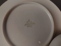 Porcelanowy zestaw śniadaniowy z niemieckiej fabryki Hertel Jacob & Co. to elegancki komplet składający się z filiżanki, spodka i talerza deserowego. Wykonana z białej, szkliwionej porcelany i bogato zdobiona złotymi, reliefowymi i malowanymi wzorami.