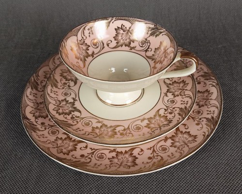 Uroczy zestaw śniadaniowy, o pięknych klasycznych kształtach. Wykonany z bardzo wysokiej klasy porcelany w kolorze ecru. Zestaw składa się z talerzyka deserowego, spodka i filiżanki. Udekorowana na pudrowo różowym tle bogatymi złoconymi.