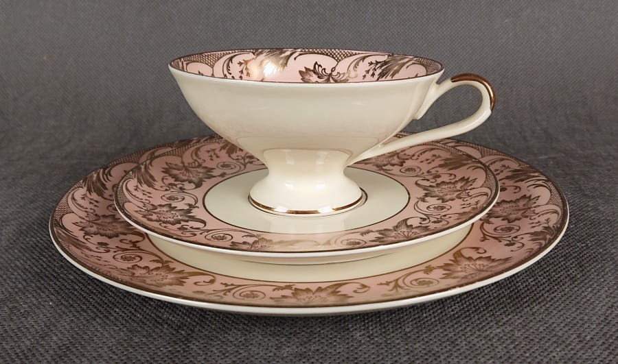 Uroczy zestaw śniadaniowy, o pięknych klasycznych kształtach. Wykonany z bardzo wysokiej klasy porcelany w kolorze ecru. Zestaw składa się z talerzyka deserowego, spodka i filiżanki. Udekorowana na pudrowo różowym tle bogatymi złoconymi.