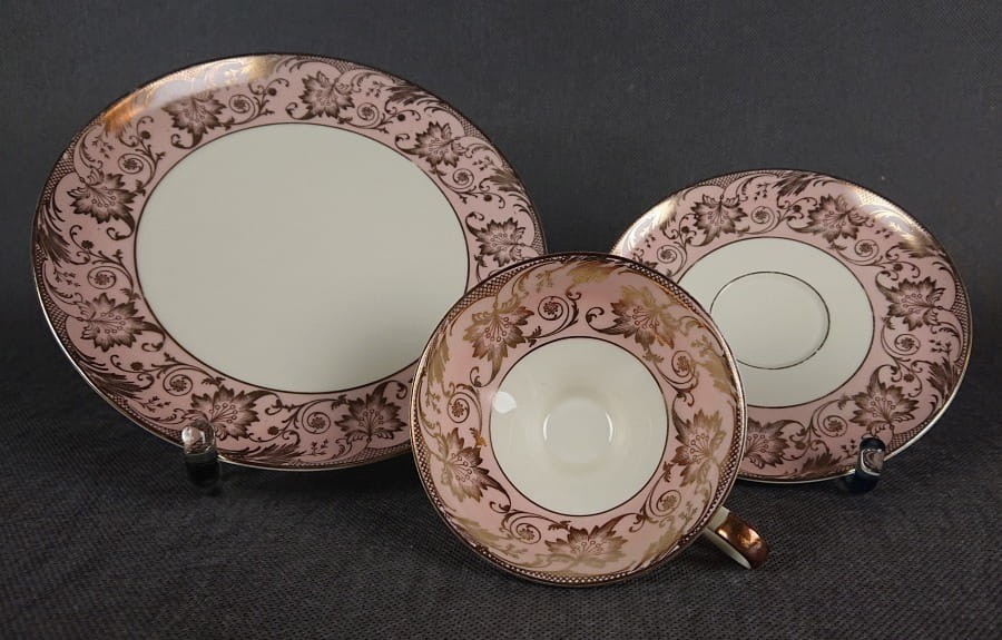 Uroczy zestaw śniadaniowy, o pięknych klasycznych kształtach. Wykonany z bardzo wysokiej klasy porcelany w kolorze ecru. Zestaw składa się z talerzyka deserowego, spodka i filiżanki. Udekorowana na pudrowo różowym tle bogatymi złoconymi.