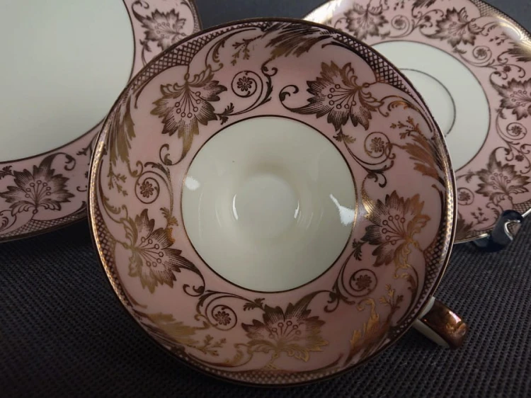 Uroczy zestaw śniadaniowy, o pięknych klasycznych kształtach. Wykonany z bardzo wysokiej klasy porcelany w kolorze ecru. Zestaw składa się z talerzyka deserowego, spodka i filiżanki. Udekorowana na pudrowo różowym tle bogatymi złoconymi.