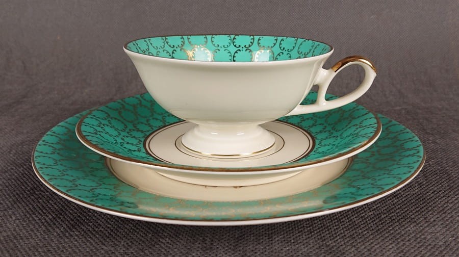 Śliczny zestaw śniadaniowy, o pięknych klasycznych kształtach. Wykonany z bardzo wysokiej klasy porcelany w kolorze ecru. Zestaw składa się z talerzyka deserowego, spodka i filiżanki. Udekorowana na zielonym tle bogatymi złoconymi.