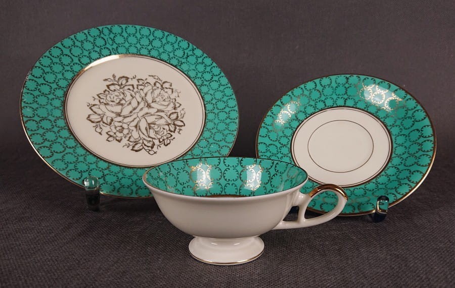 Śliczny zestaw śniadaniowy, o pięknych klasycznych kształtach. Wykonany z bardzo wysokiej klasy porcelany w kolorze ecru. Zestaw składa się z talerzyka deserowego, spodka i filiżanki. Udekorowana na zielonym tle bogatymi złoconymi.