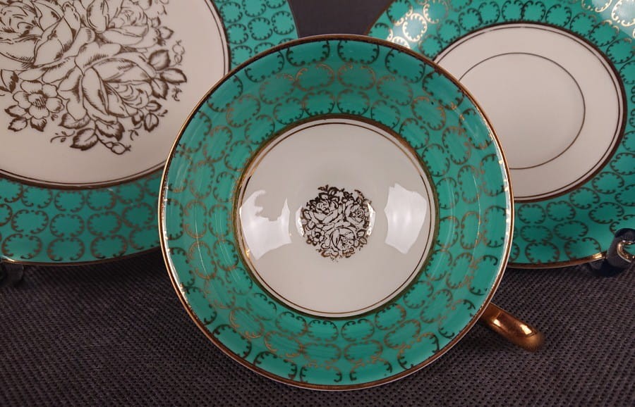 Śliczny zestaw śniadaniowy, o pięknych klasycznych kształtach. Wykonany z bardzo wysokiej klasy porcelany w kolorze ecru. Zestaw składa się z talerzyka deserowego, spodka i filiżanki. Udekorowana na zielonym tle bogatymi złoconymi.