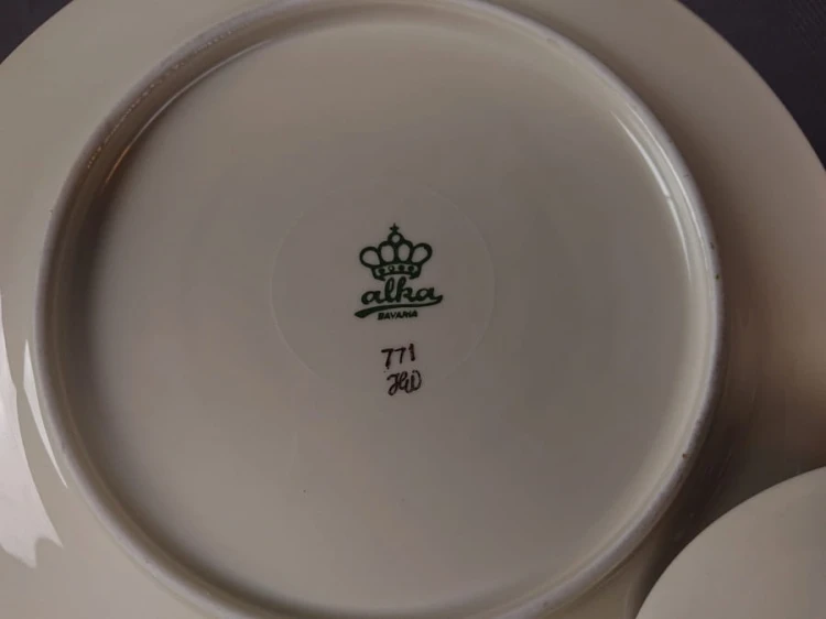 Śliczny zestaw śniadaniowy, o pięknych klasycznych kształtach. Wykonany z bardzo wysokiej klasy porcelany w kolorze ecru. Zestaw składa się z talerzyka deserowego, spodka i filiżanki. Udekorowana na zielonym tle bogatymi złoconymi.