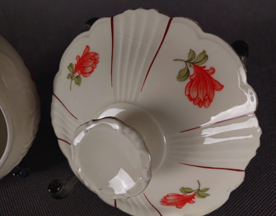 Duża bomboniera w stylu art-deco z porcelany, pochodząca z Dolnego Śląska. Wykonana z porcelany w kolorze ecru o kulistej formie wsparta podstawie w formie falbany, na szczególną uwagę zasługuje finezyjny uchwyt na pokrywce.