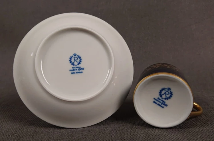 Filiżanka ze spodkiem do kawy espresso, pochodzi z drugiej połowy XX. wieku. Zestaw wykonany z wyjątkowo delikatnej dobrej jakości cienkiej białej porcelany.  Filiżanka i spodek dekorowana kobaltem a na tym tle złote dekoracja.