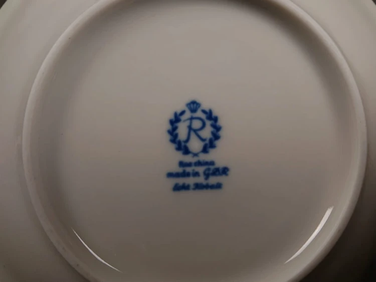 Filiżanka ze spodkiem do kawy espresso, pochodzi z drugiej połowy XX. wieku. Zestaw wykonany z wyjątkowo delikatnej dobrej jakości cienkiej białej porcelany.  Filiżanka i spodek dekorowana kobaltem a na tym tle złote dekoracja.