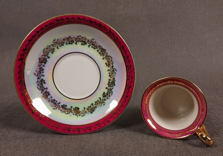 Espresso filiżanka ze scenką Martinroda Fridrich. Porcelanowa filiżanka ze spodkiem do espresso, wyprodukowana w niemieckiej fabryce porcelany Martinroda, prezentuje wyrafinowany styl rokoko, charakteryzuje się bogatym zdobieniami i perłowym połyskiem.