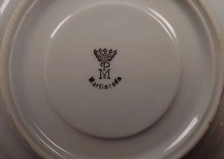 Espresso filiżanka ze scenką Martinroda Fridrich. Porcelanowa filiżanka ze spodkiem do espresso, wyprodukowana w niemieckiej fabryce porcelany Martinroda, prezentuje wyrafinowany styl rokoko, charakteryzuje się bogatym zdobieniami i perłowym połyskiem.