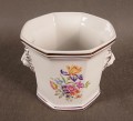 Przedmiot został wykonany z wysokiej jakości białej porcelany. Osłonka ma charakterystyczny, ośmiokątny korpus, który rozszerza się ku górze.