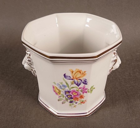 Przedmiot został wykonany z wysokiej jakości białej porcelany. Osłonka ma charakterystyczny, ośmiokątny korpus, który rozszerza się ku górze.