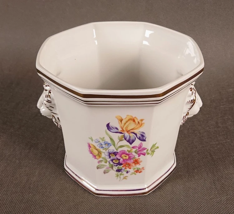 Przedmiot został wykonany z wysokiej jakości białej porcelany. Osłonka ma charakterystyczny, ośmiokątny korpus, który rozszerza się ku górze.