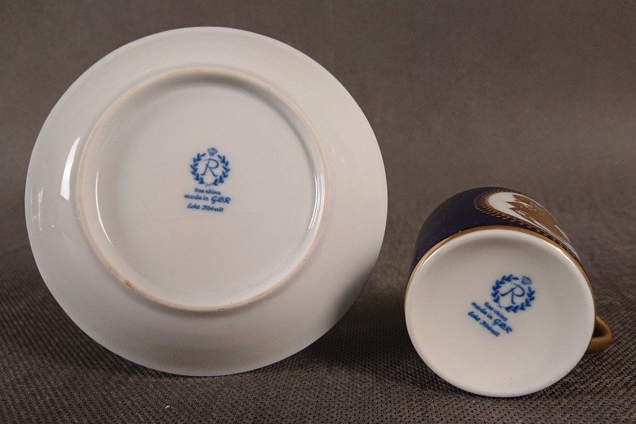 Symbol: Litera „R” wpisana w wieniec laurowy, zwieńczona koroną – znak towarowy manufaktury Reichenbach. Napisy: „fine china”, „made in G.D.R.” (wyprodukowano w NRD) oraz „Echt Kobalt”.