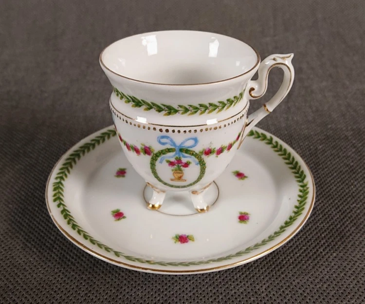 Elegancka, miniaturowa filiżanka do espresso (mokki) ze spodkiem, wykonana z cienkościennej, białej porcelany. Zestaw bogato ręcznie malowany i złocony.