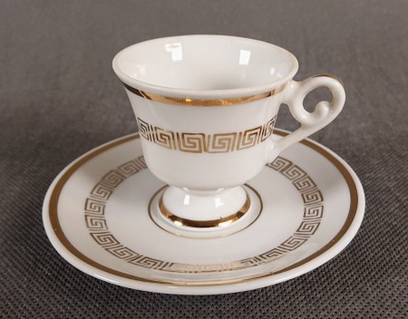 Ten elegancki zestaw do espresso to klasyczny przykład niemieckiej porcelany dekoracyjnej, łączący surową biel z bogatym, złotym zdobnictwem.