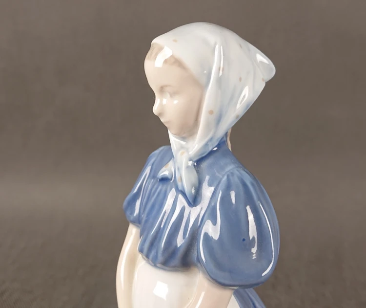 Detal rzeźby figuralnej Royal Copenhagen 527 - precyzja wykonania postaci gęsiarki.