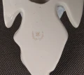 Złota sygnatura wytwórni na spodzie kropielniczki porcelanowej