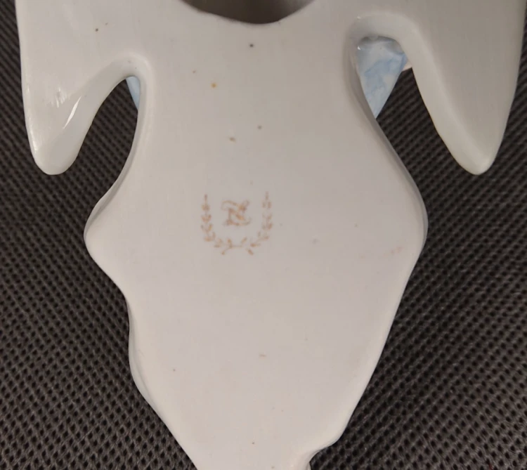 Złota sygnatura wytwórni na spodzie kropielniczki porcelanowej