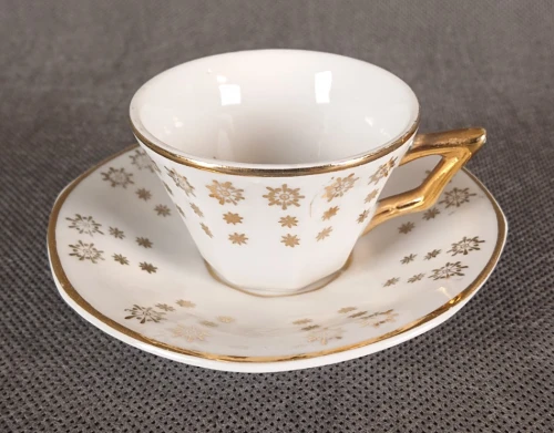 Biała porcelanowa filiżanka do espresso ze złotym geometrycznym wzorem