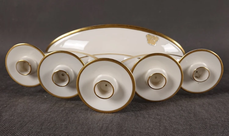 Zbliżenie na złocone ramiona i tuleje na świece w porcelanowym świeczniku