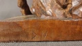 Wyraźny monogram rzeźbiarza D.N na drewnianej podstawie figury