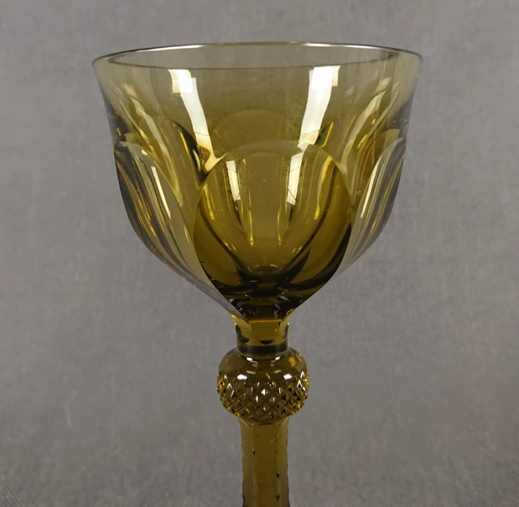 Antyczny kieliszek oliwkowy ze Szczytnej, ujęcie od góry pokazujące geometryczne szlify wewnątrz czary oraz papierową nalepkę na stopie.