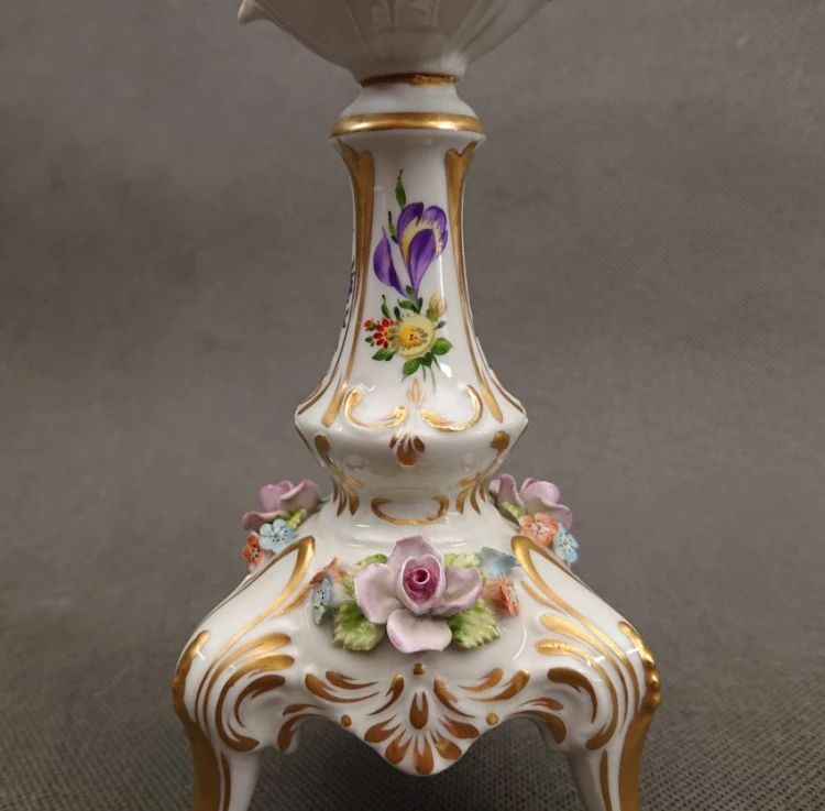 Zbliżenie na podstawę świecznika z nakładaną przestrzenną różą 3D i zielonymi listkami z porcelany