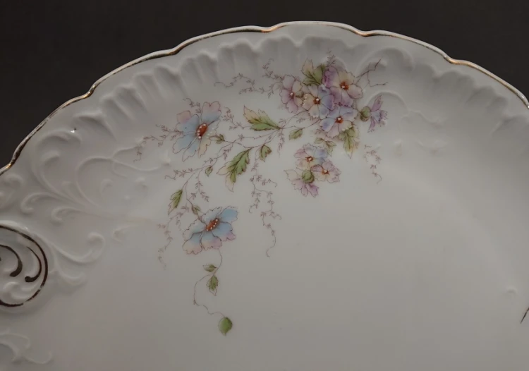 Zbliżenie na pastelowy bukiet niebieskich i fioletowych kwiatów na tle śnieżnobiałej porcelany