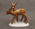 Porcelanowa figurka przedstawiająca parkę brązowych sarenek na białym cokoliku, widok z boku