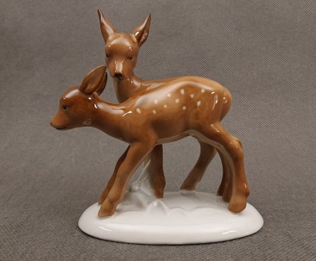 Porcelanowa figurka przedstawiająca parkę brązowych sarenek na białym cokoliku, widok z boku