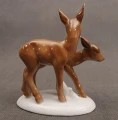 Porcelanowa figurka przedstawiająca parkę brązowych sarenek na białym cokoliku, widok z boku