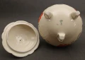 Widok na spód porcelanowego naczynia z trzema nóżkami i widoczną zieloną sygnaturą podszkliwną