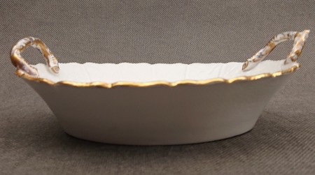 Bok porcelanowej miseczki ukazujący podłużny profil oraz falowaną krawędź ze złotym rantem